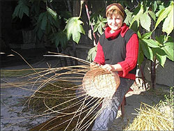 Олена Ярмакович на своєму подвір’ї в селі Іза Хустського району Закарпатської області плете з лози кошик для квітів (фото: Сніжана РУСИН) 